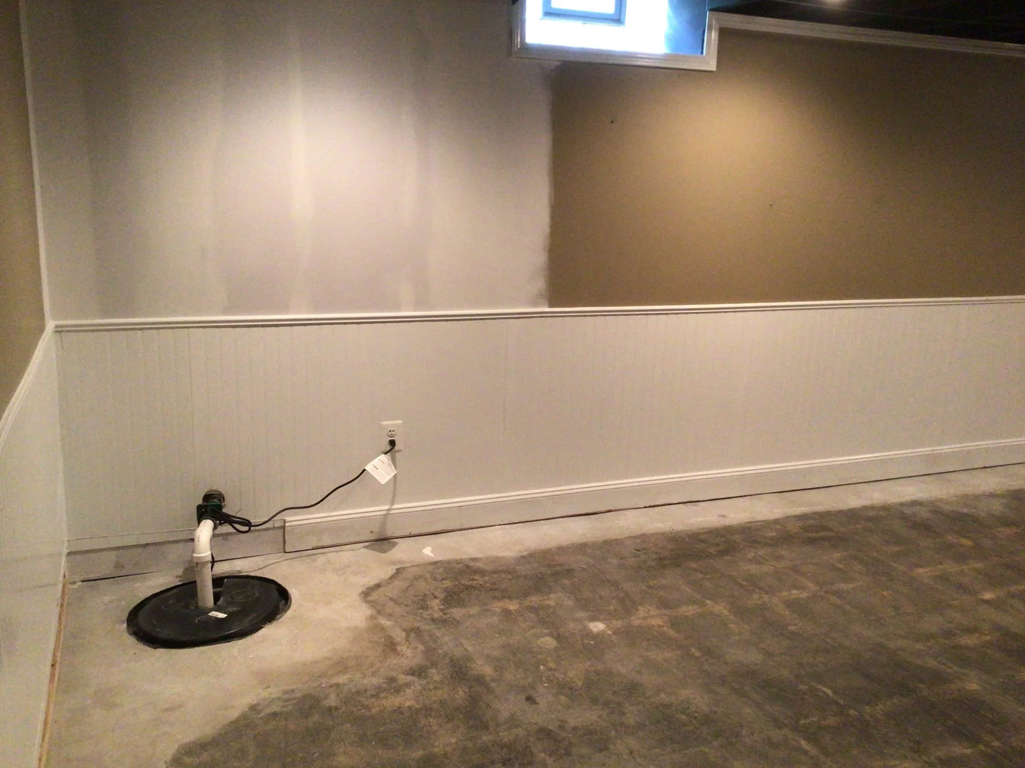 Refinished basement in Sterling Heights after waterproofing system installation and wall restoration.