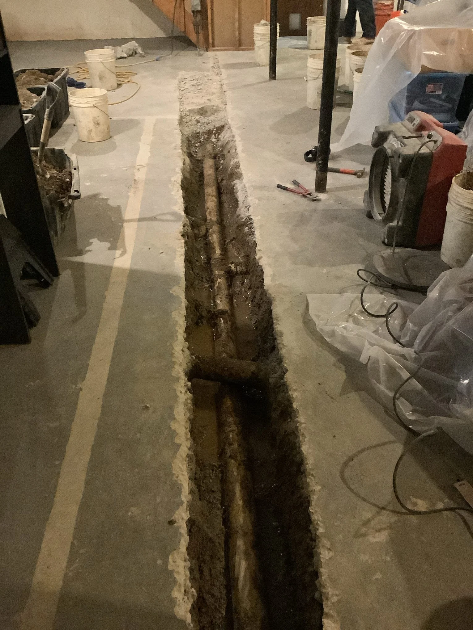 Basement in Rochester Hills experiencing water accumulation due to an ineffective non-perimeter drainage system.