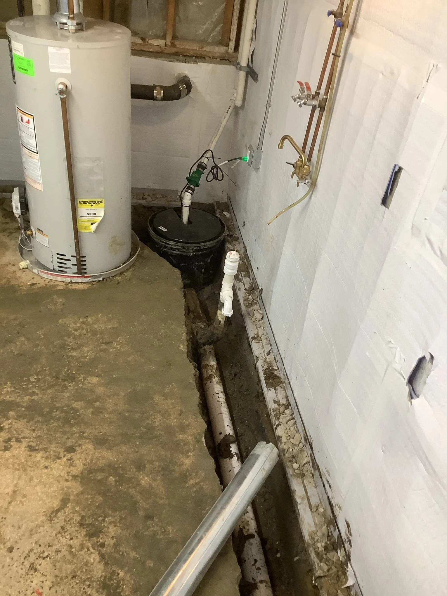 Completed basement waterproofing system in Fraser, Michigan with drain tile, sump pump, and vapor barrier installed.