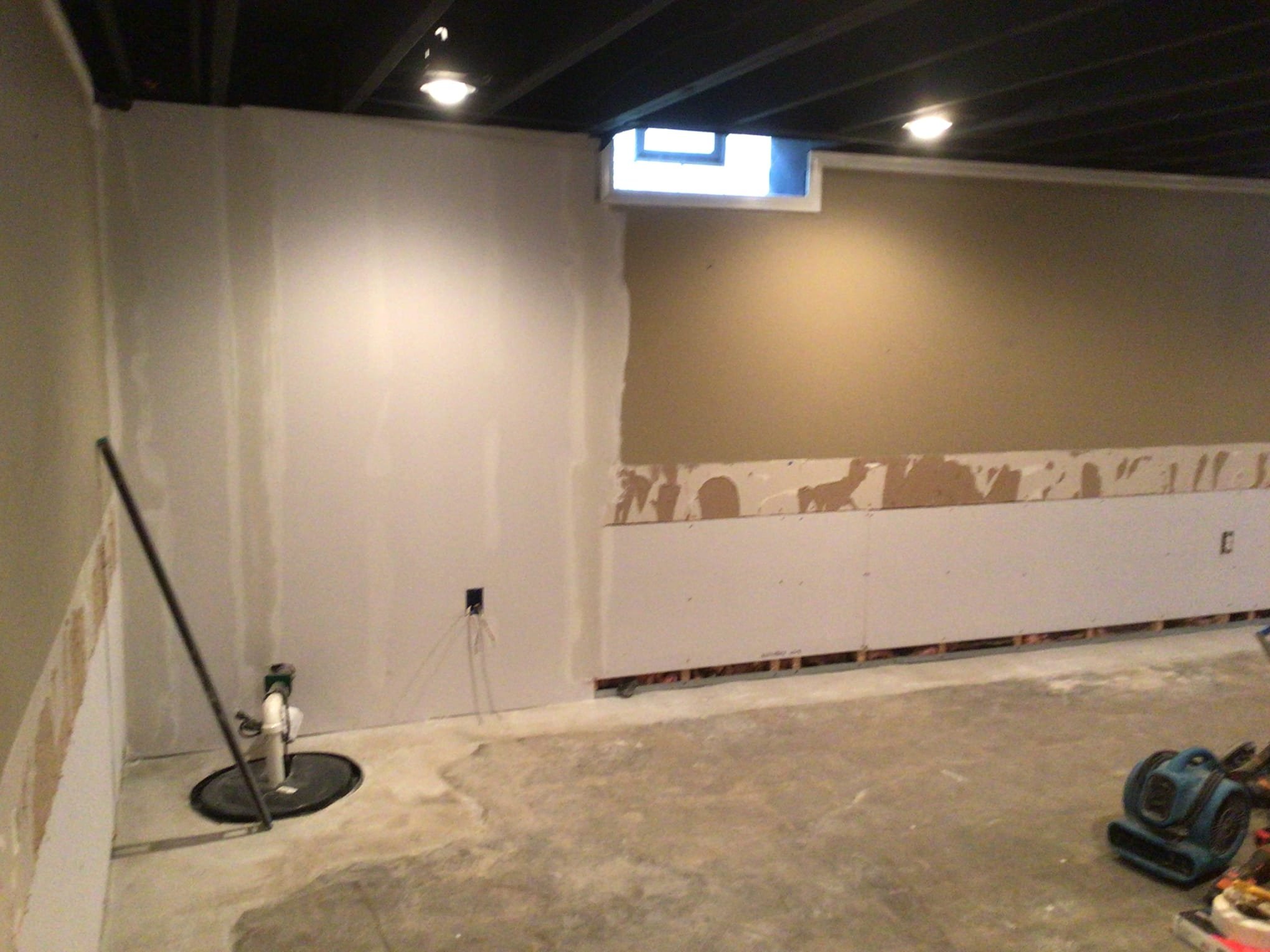 Refinished basement in Sterling Heights after waterproofing system installation and wall restoration.