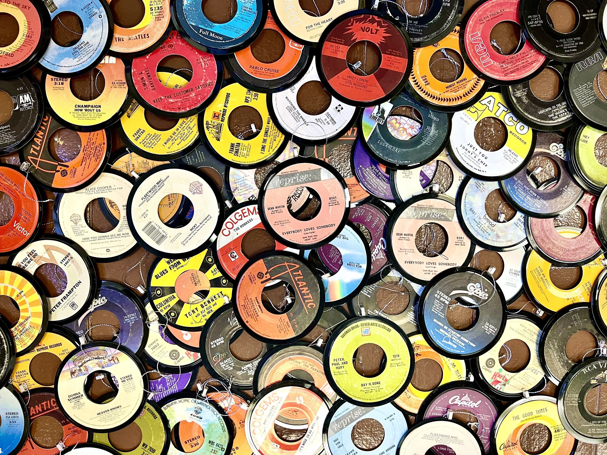 A collection of vintage 45 RPM vinyl record labels overlapping each other, featuring various artists and genres.