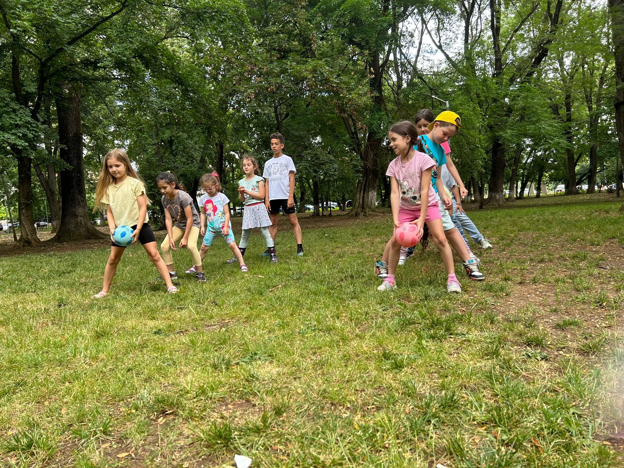 Children playing a game with balls in a park.