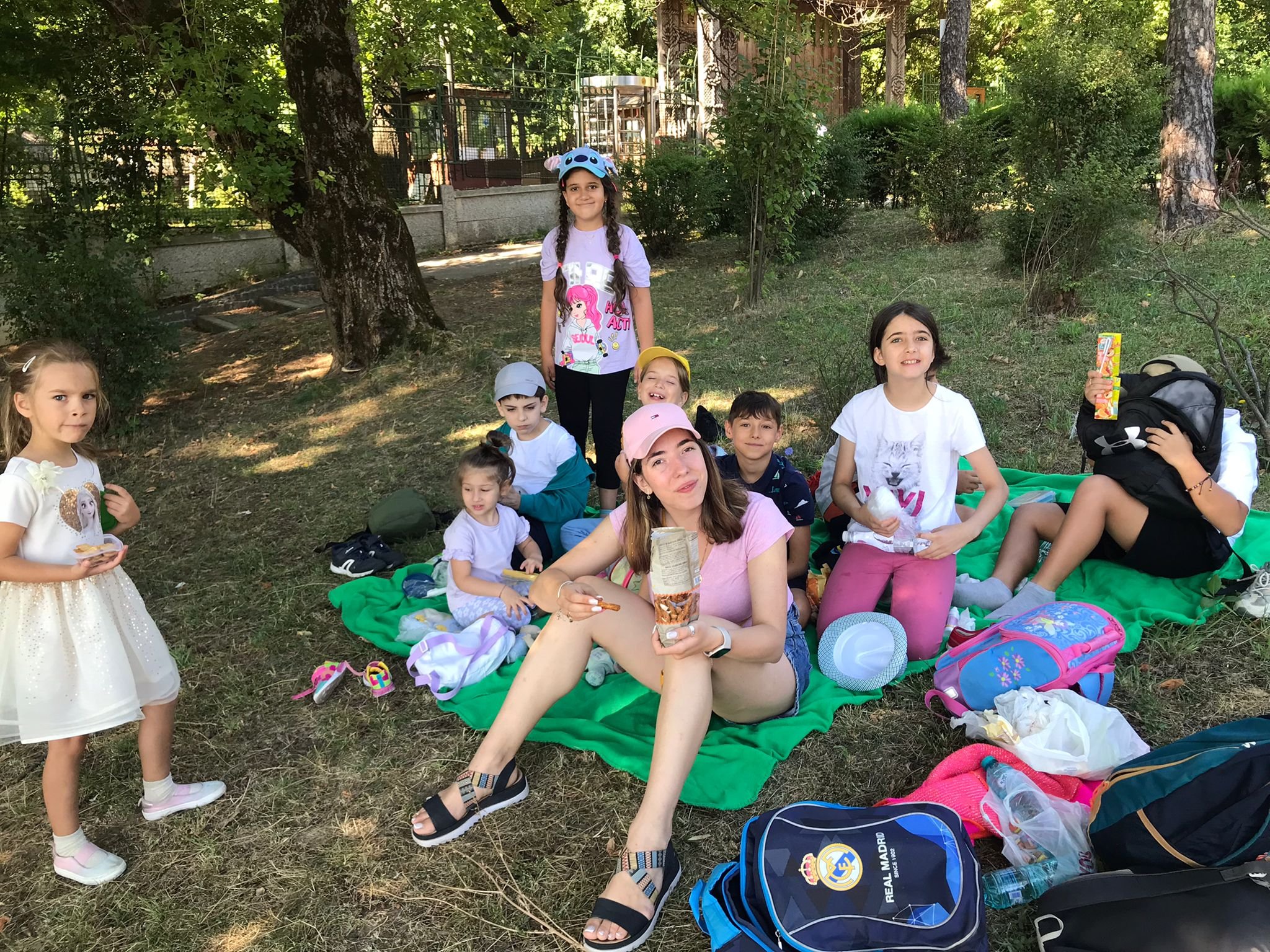 Group of people having a picnic in a park with snacks and backpacks
