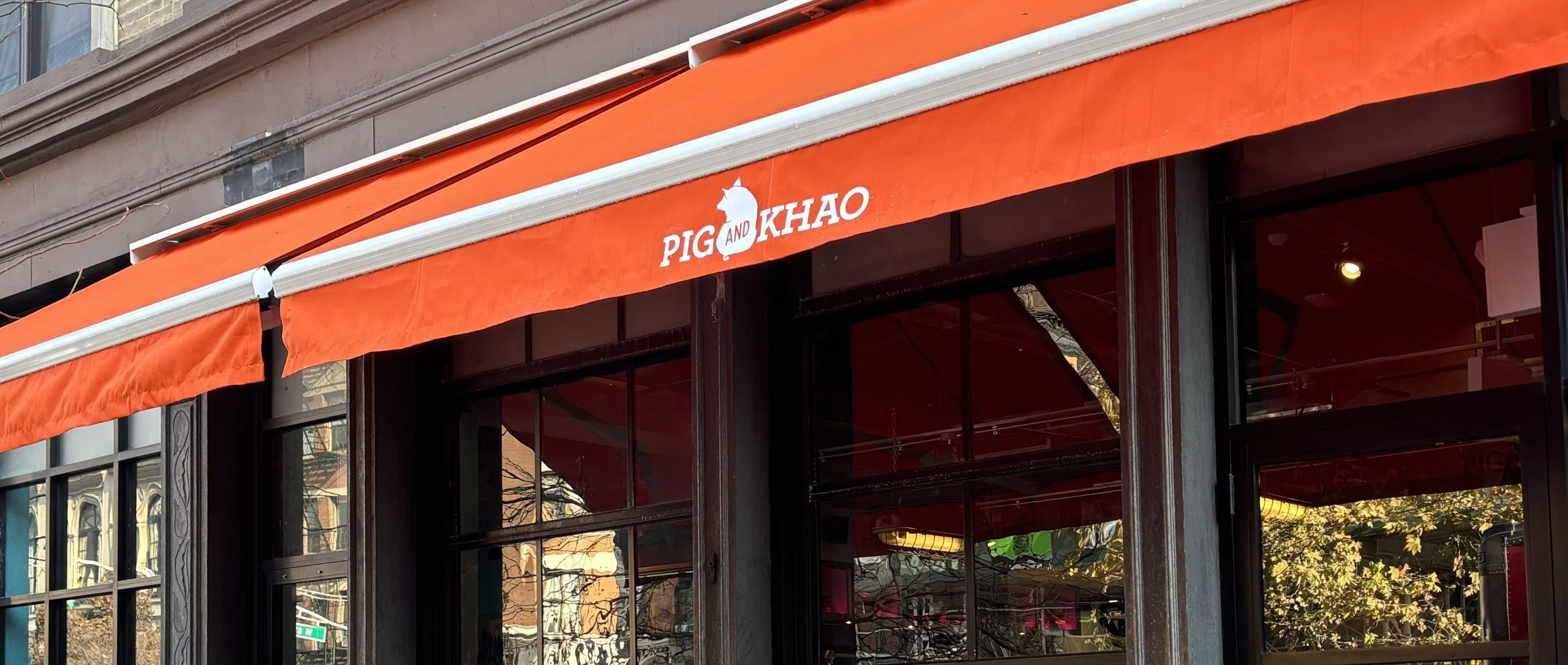 The Pig and Khao storefront and orange awning on the Upper West Side