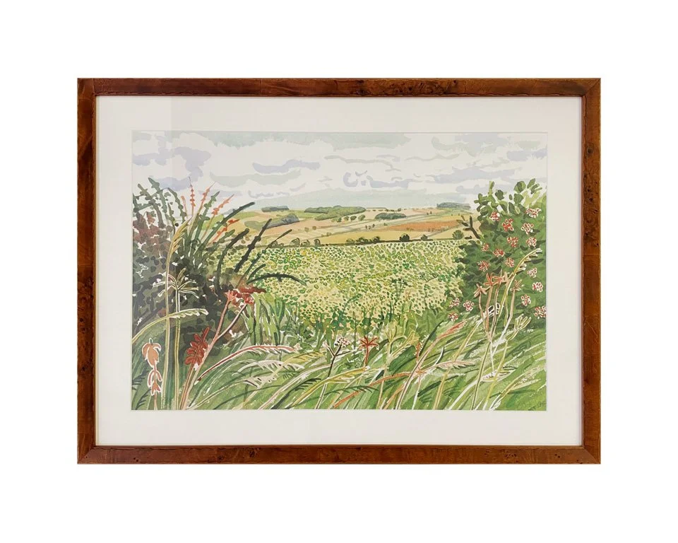 A watercolor painting of a lush green landscape with fields, trees, and rolling hills under a cloudy sky, framed in wood.
