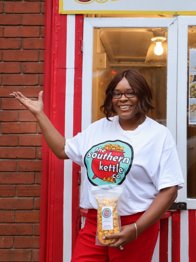Southern Kettle Co. co-founder Desiree McMurry-Ellis holding a bag of popcorn in front of the Corn Crib in downtown Gallatin.