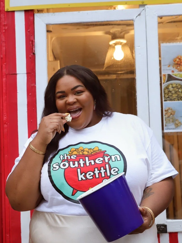 Southern Kettle Co. founder Kaneisha Dotson eating popcorn in front of the Corn Crib in downtown Gallatin.
