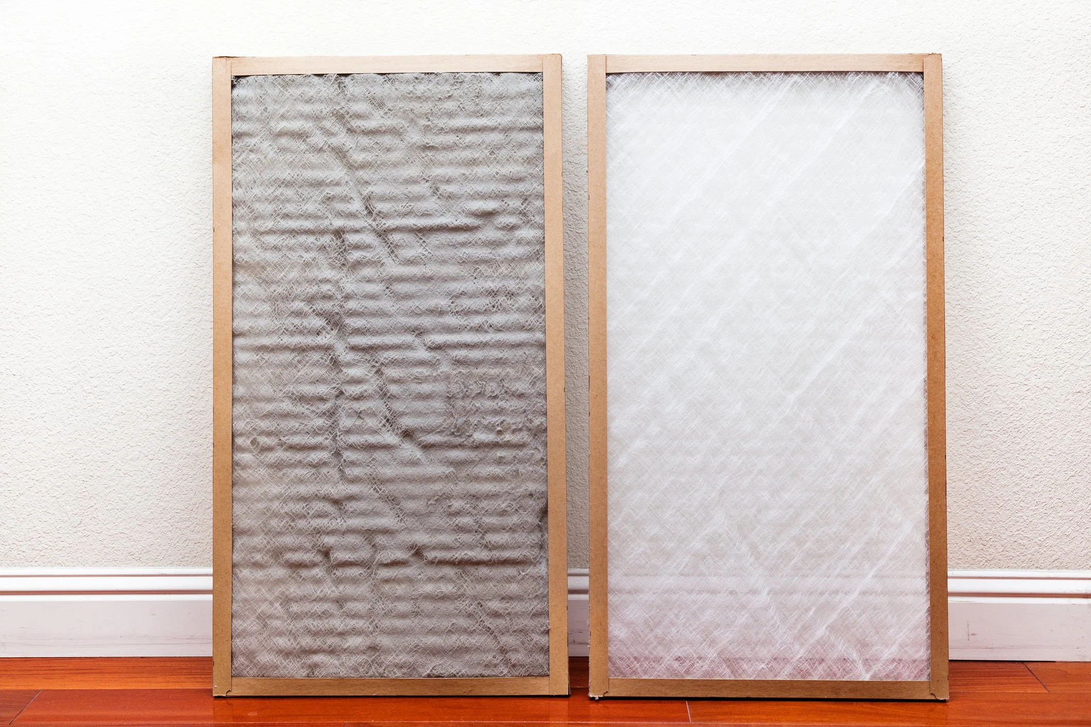 A direct comparison between a dirty, clogged HVAC air filter and a new, clean replacement filter, used on the Bodnar HVAC maintenance page to illustrate how filter services improve system efficiency.