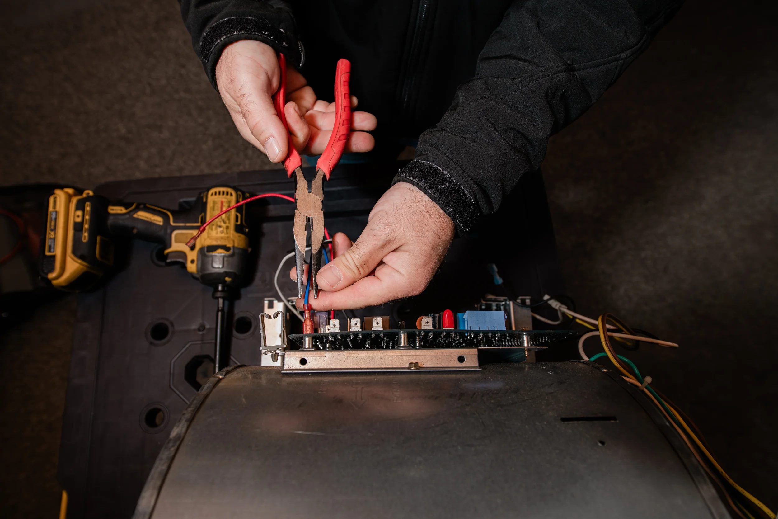 A Bodnar HVAC technician using precision tools to repair a furnace control board during a comprehensive system diagnostic in San Carlos.