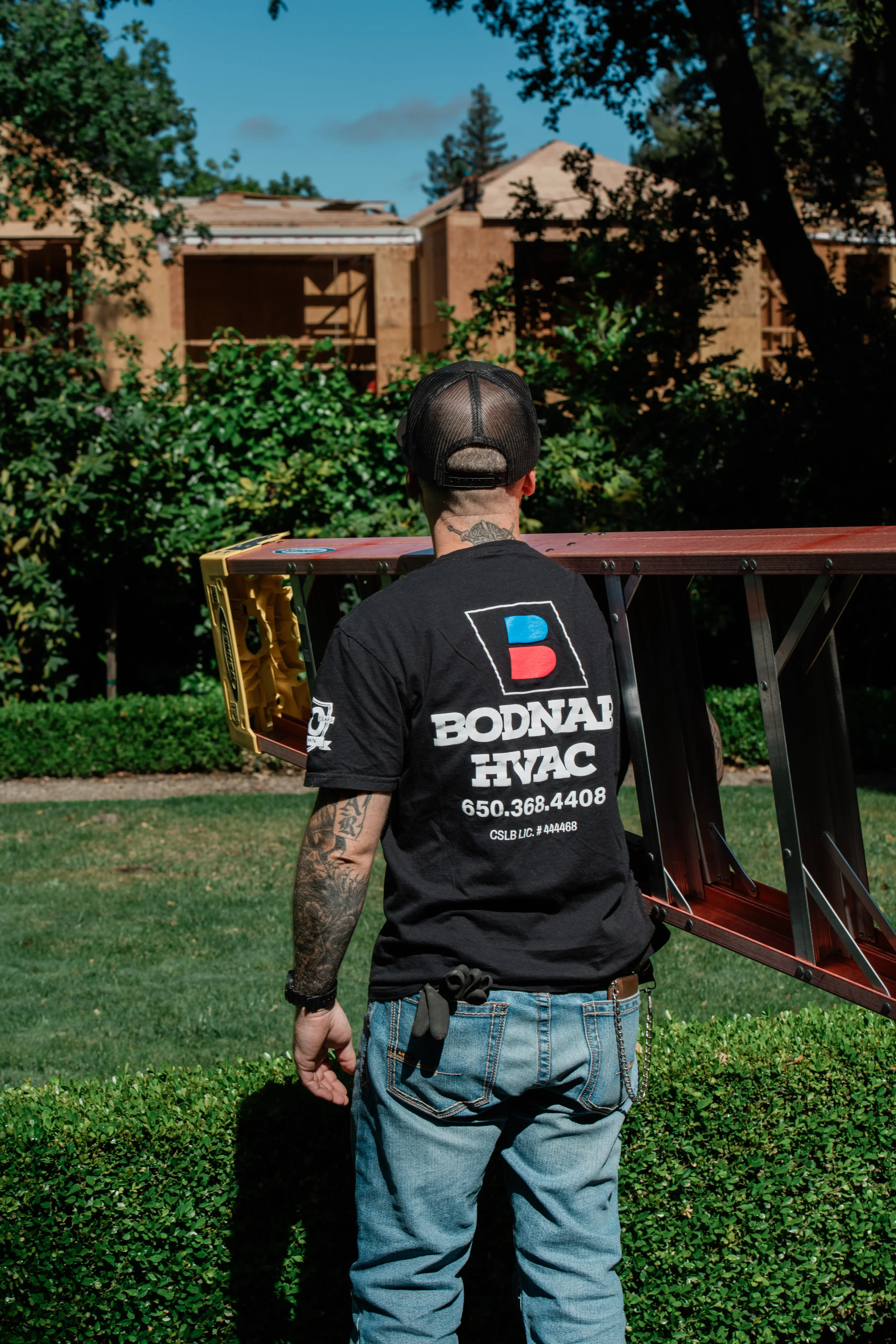 Owner John Bodnar carrying a ladder at a Menlo Park job site, representing Bodnar HVAC’s commitment to no-commission service and honest residential heating and air repairs.