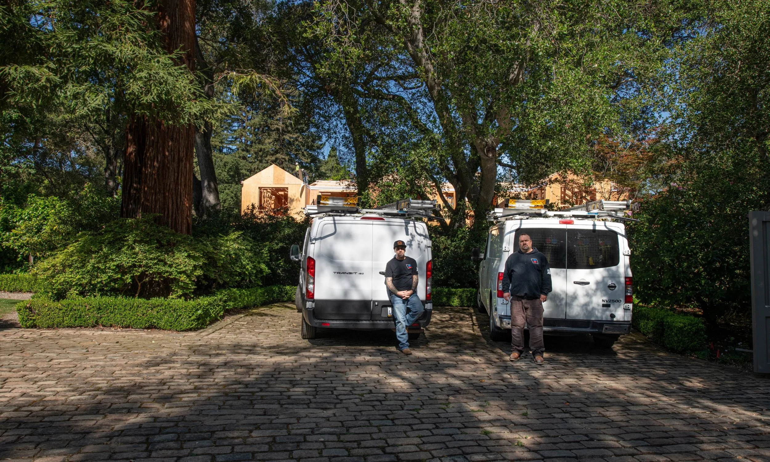 The Bodnar HVAC team and service vans parked at a residential job site, providing specialized heating and cooling services.
