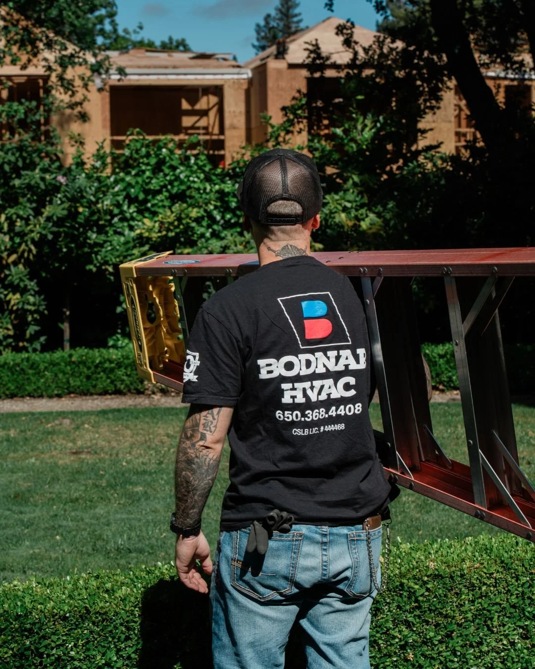 Owner John Bodnar carrying a ladder at a Menlo Park job site, representing Bodnar HVAC’s commitment to no-commission service and honest residential heating and air repairs.