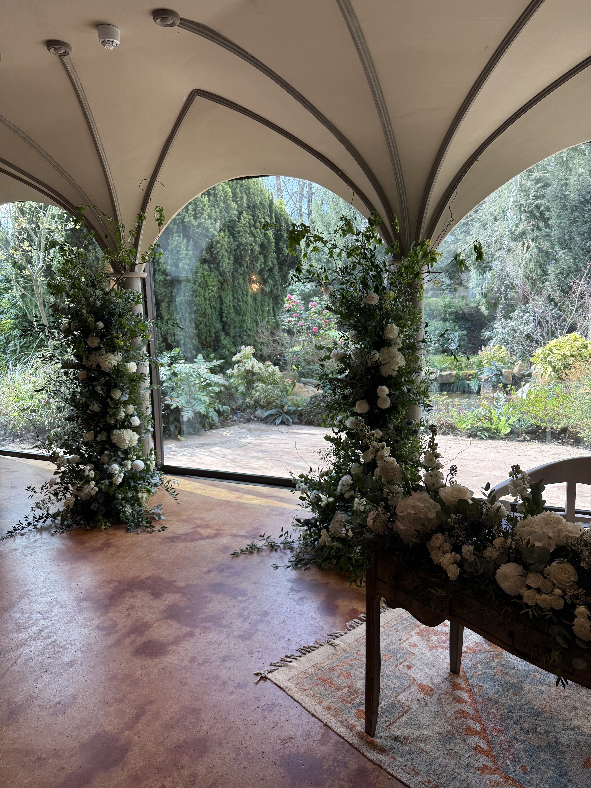 Ceremony room with floral columns and a register table meadow