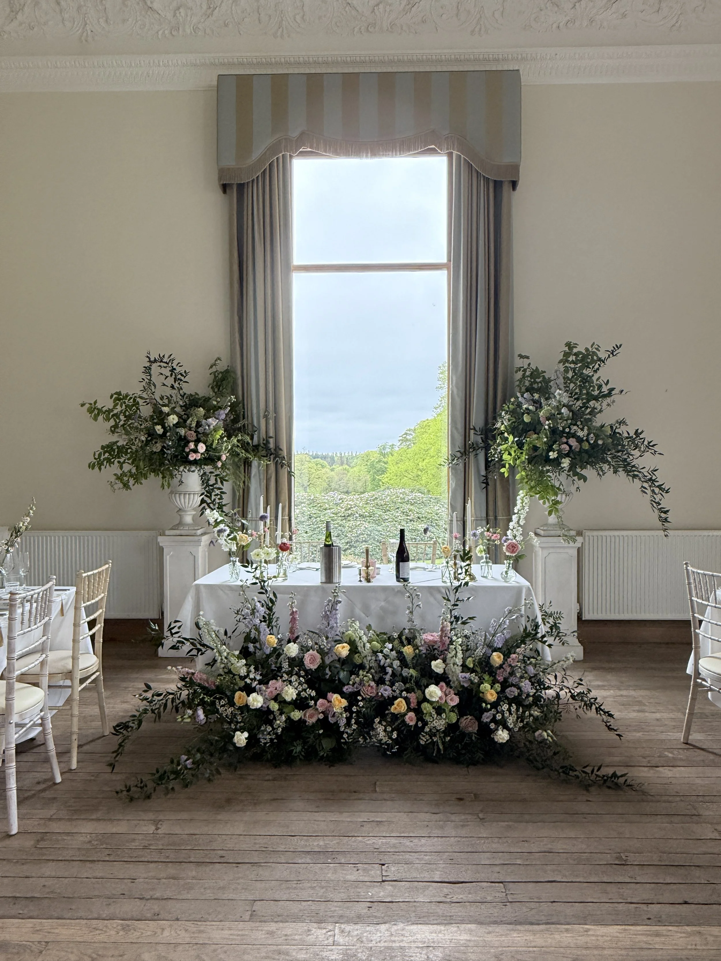 Large scale urn and meadow designs framing the sweetheart table