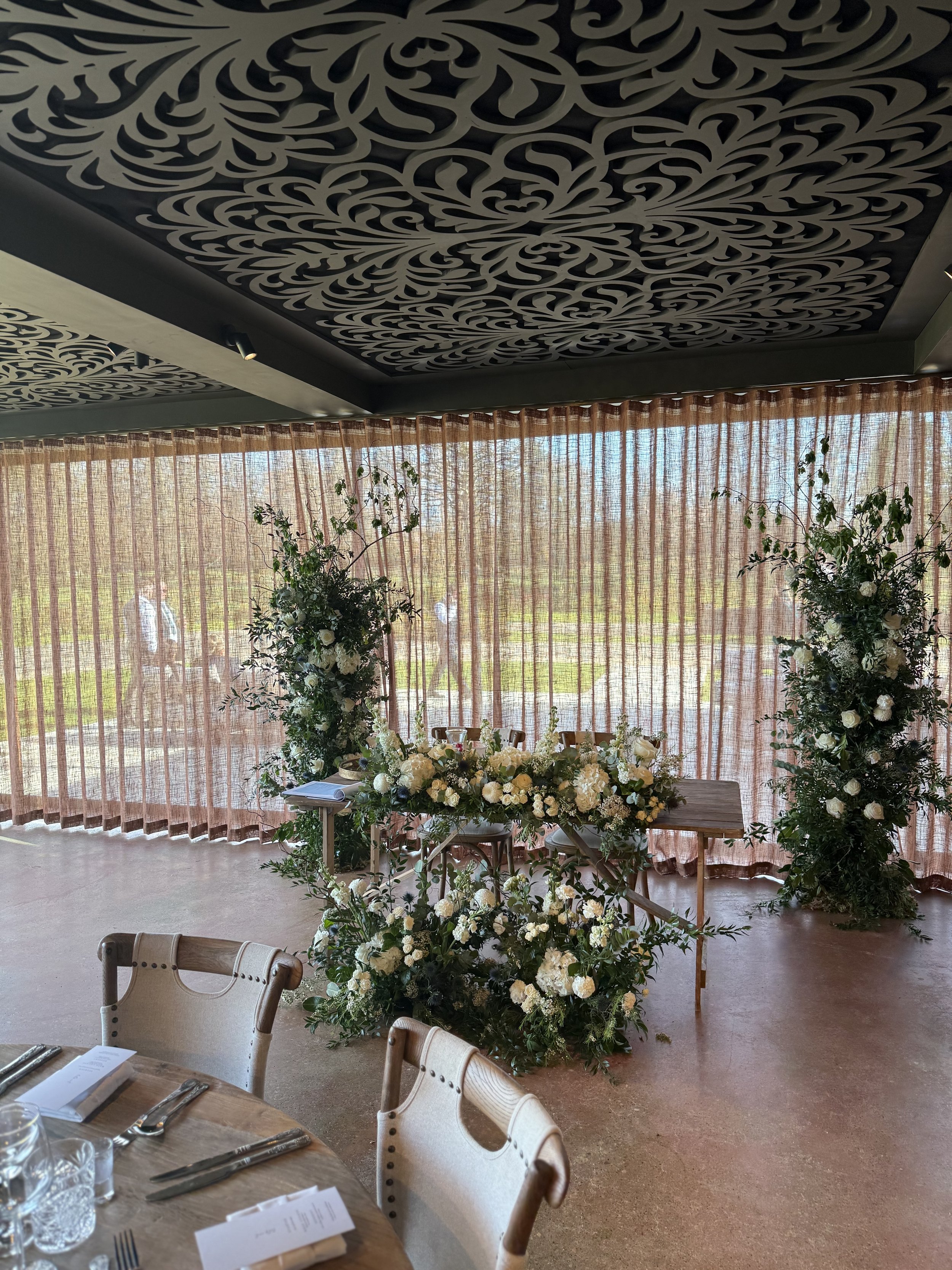 Ceremony floral columns and floor meadows repurposed to the sweetheart table