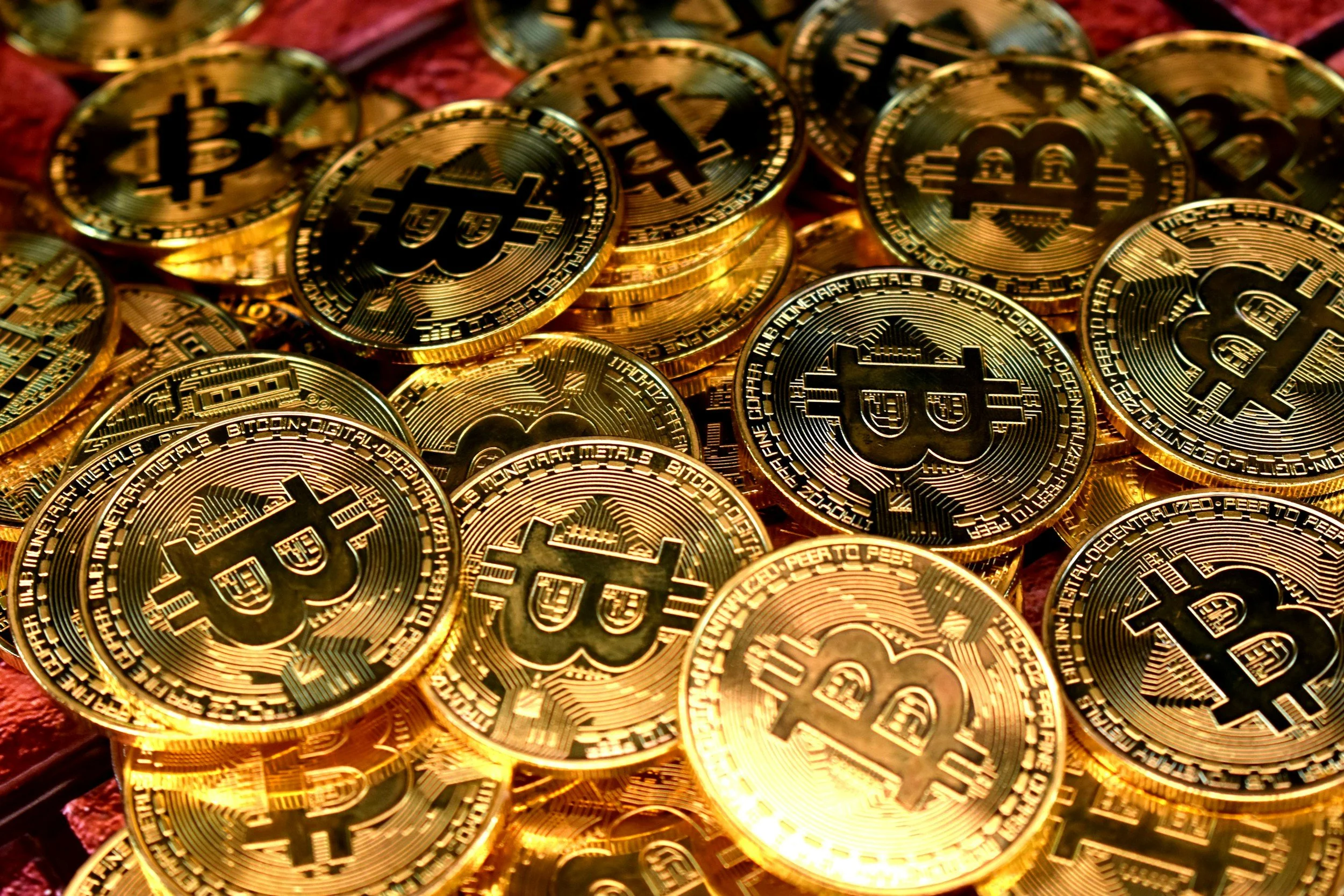 Gold bitcoins with the Bitcoin logo on a pile