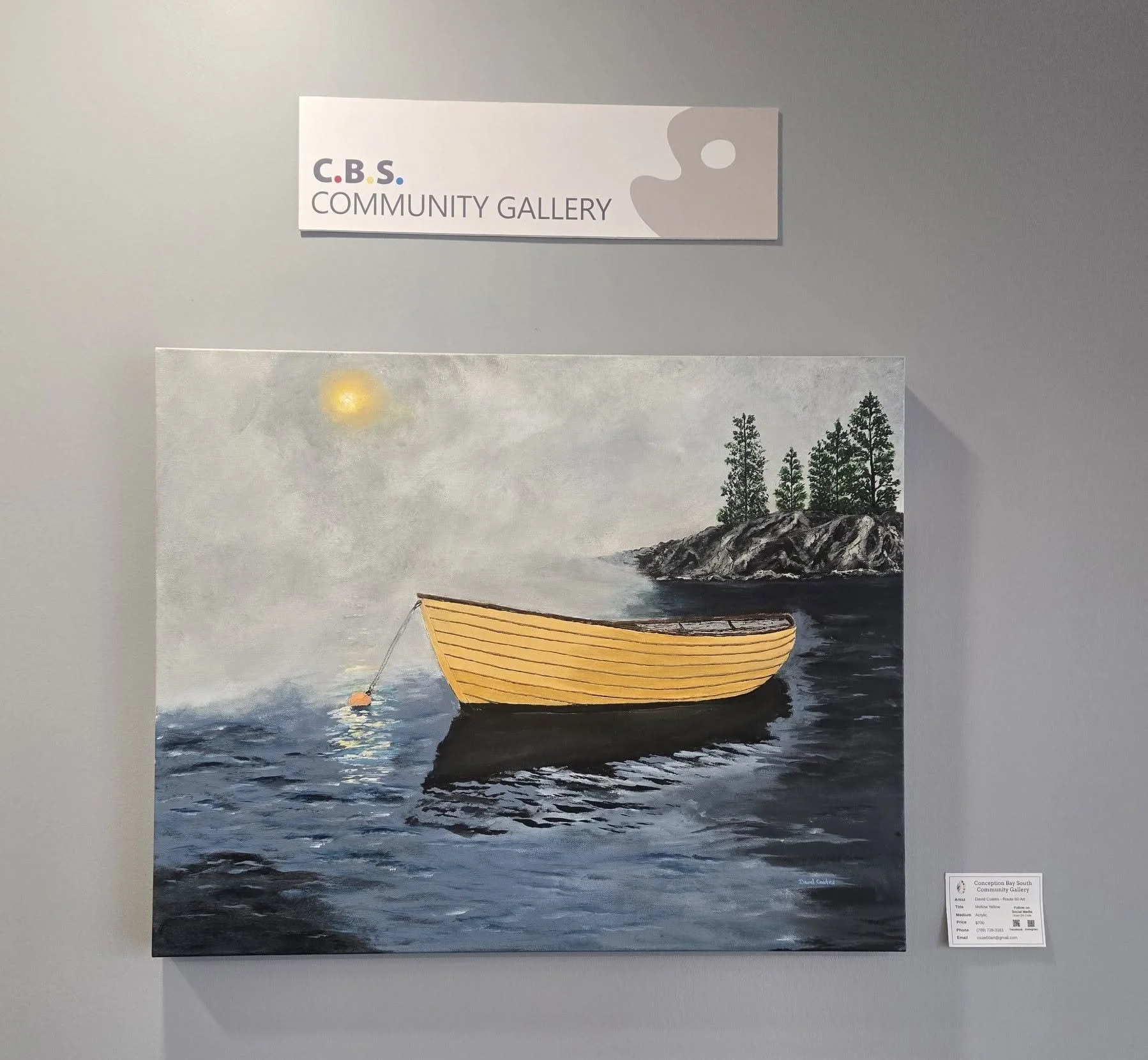 A painting of a boat at anchor with the sun in a cloudy sky and trees behind. Above is a white sign that says "C.B.S. Community Gallery."