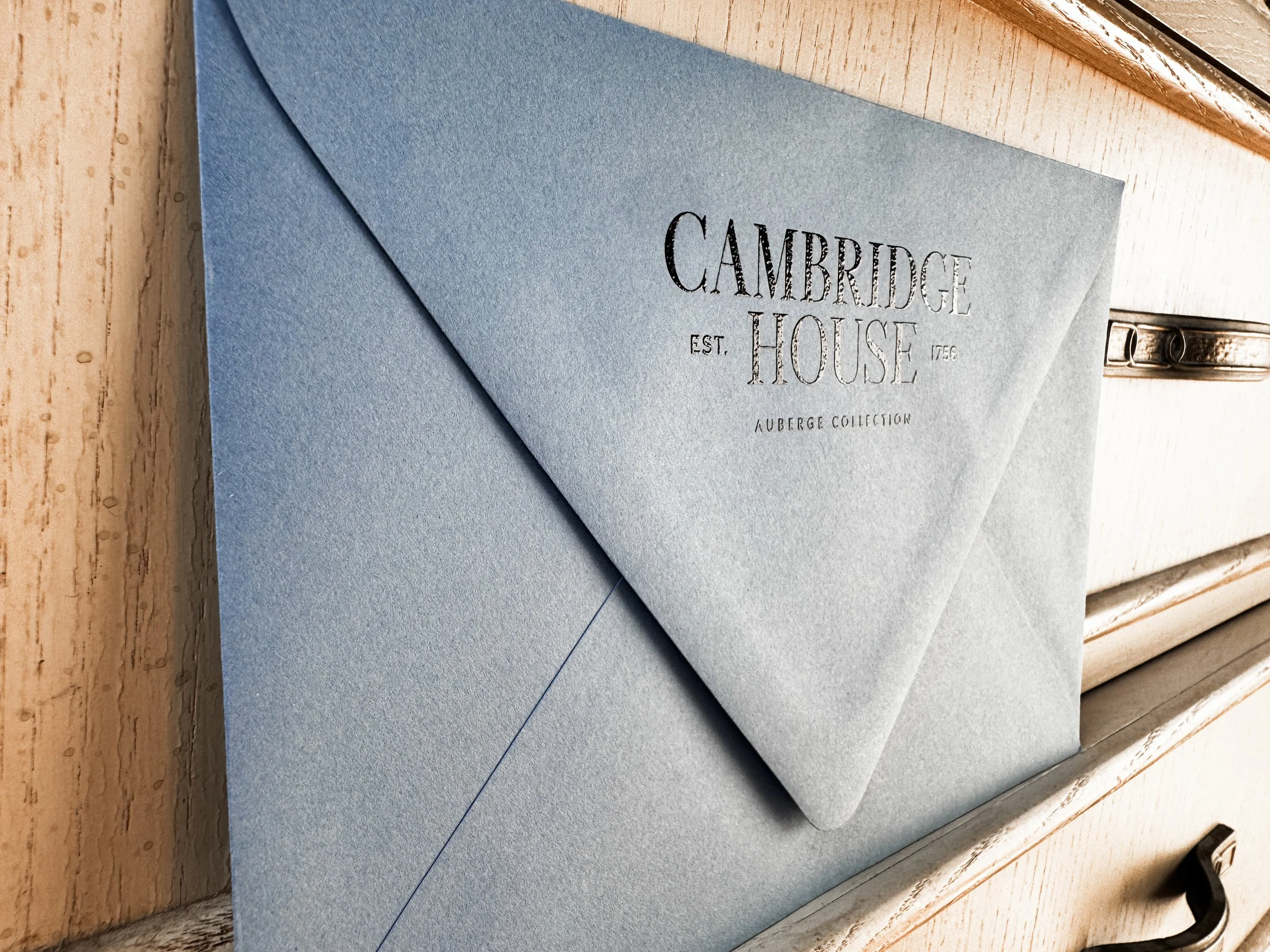 Raised Ink Printing on a Dusty Blue colored Custom Envelope for The Cambridge House 