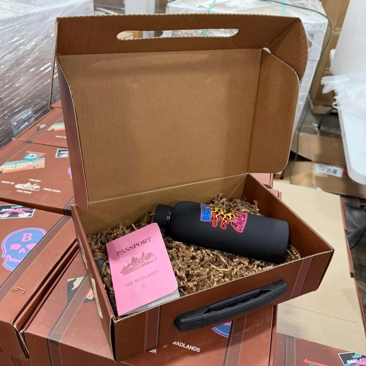 Custom Mailer Boxes packed with a branded hot pink passport book and custom printed tumbler bottle