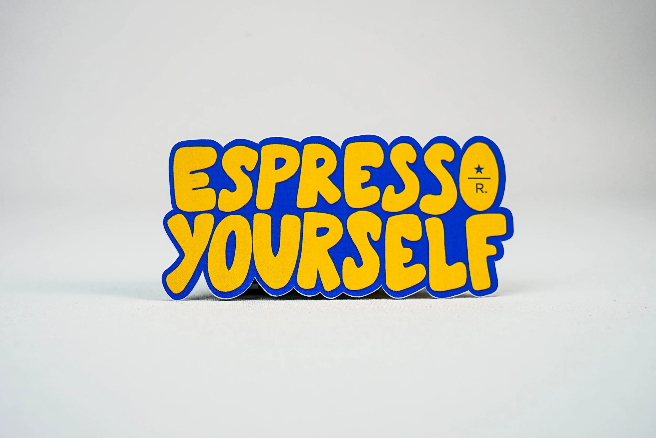 Custom Coffee Shop Sticker that says Espresso Yourself in yellow and blue