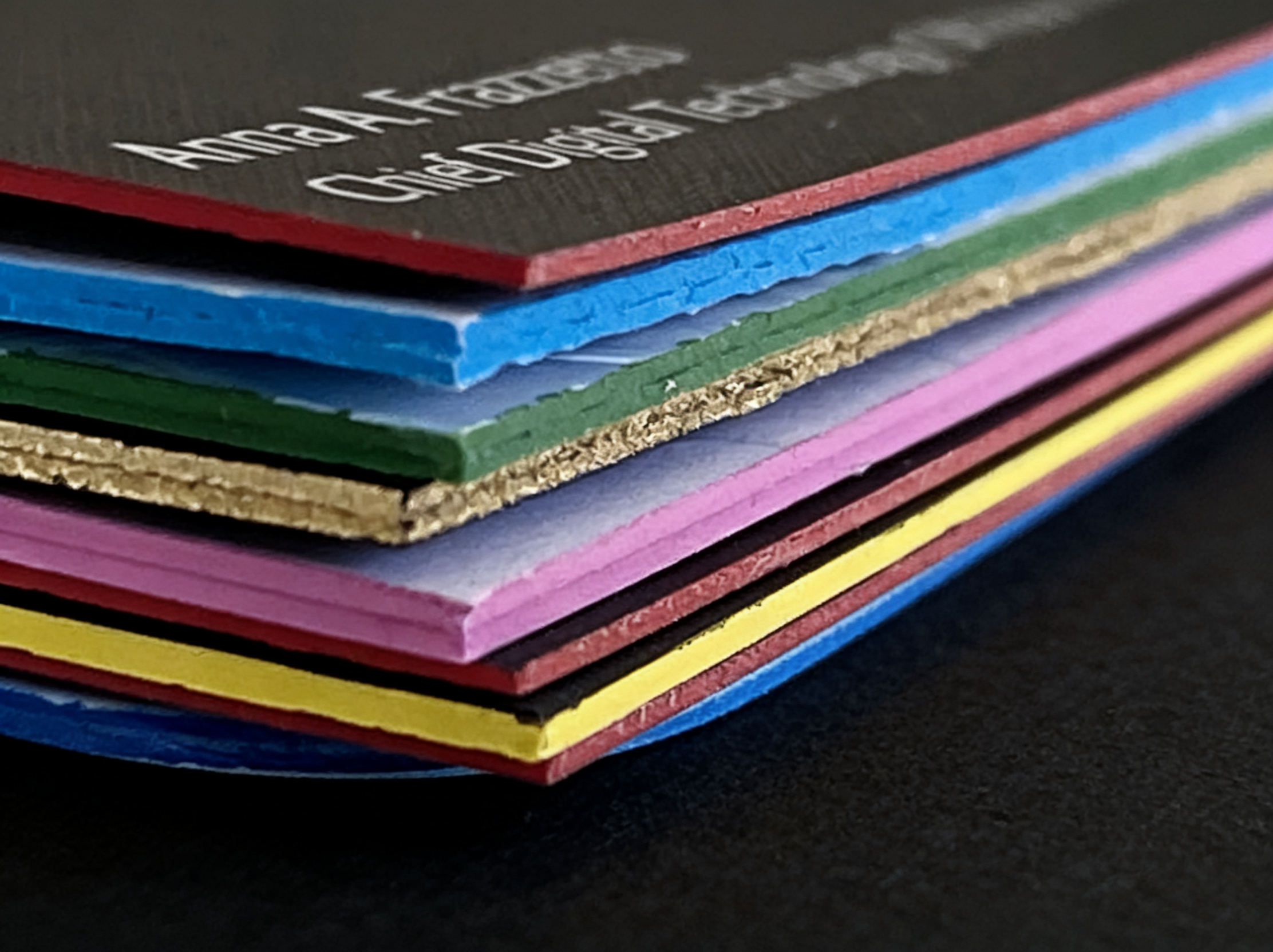 Close-up of colorful layered business cards printed with an edge painted finish.