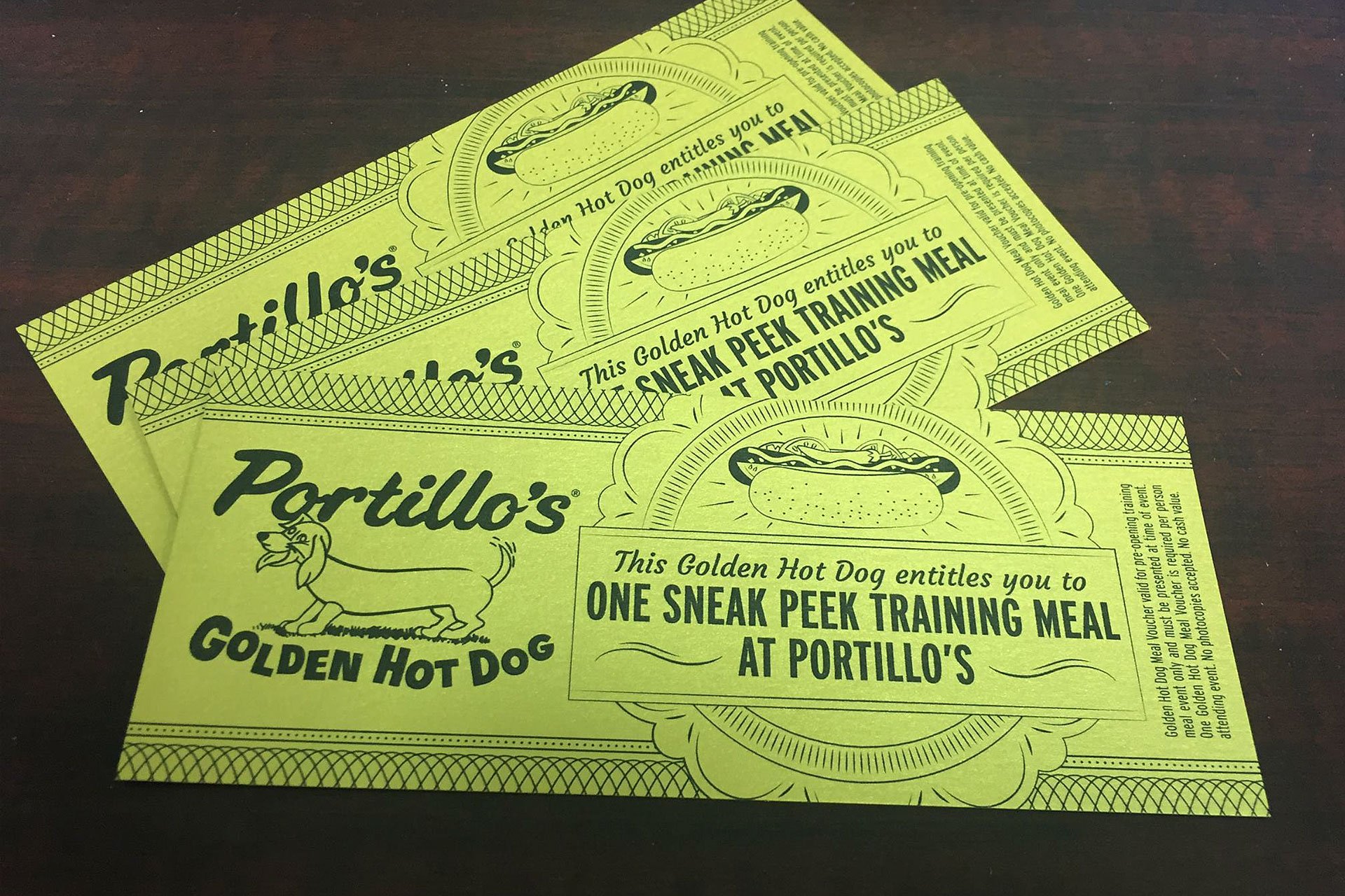 Portillo's Golden Hot Dog sneak peek training meal vouchers on a table.