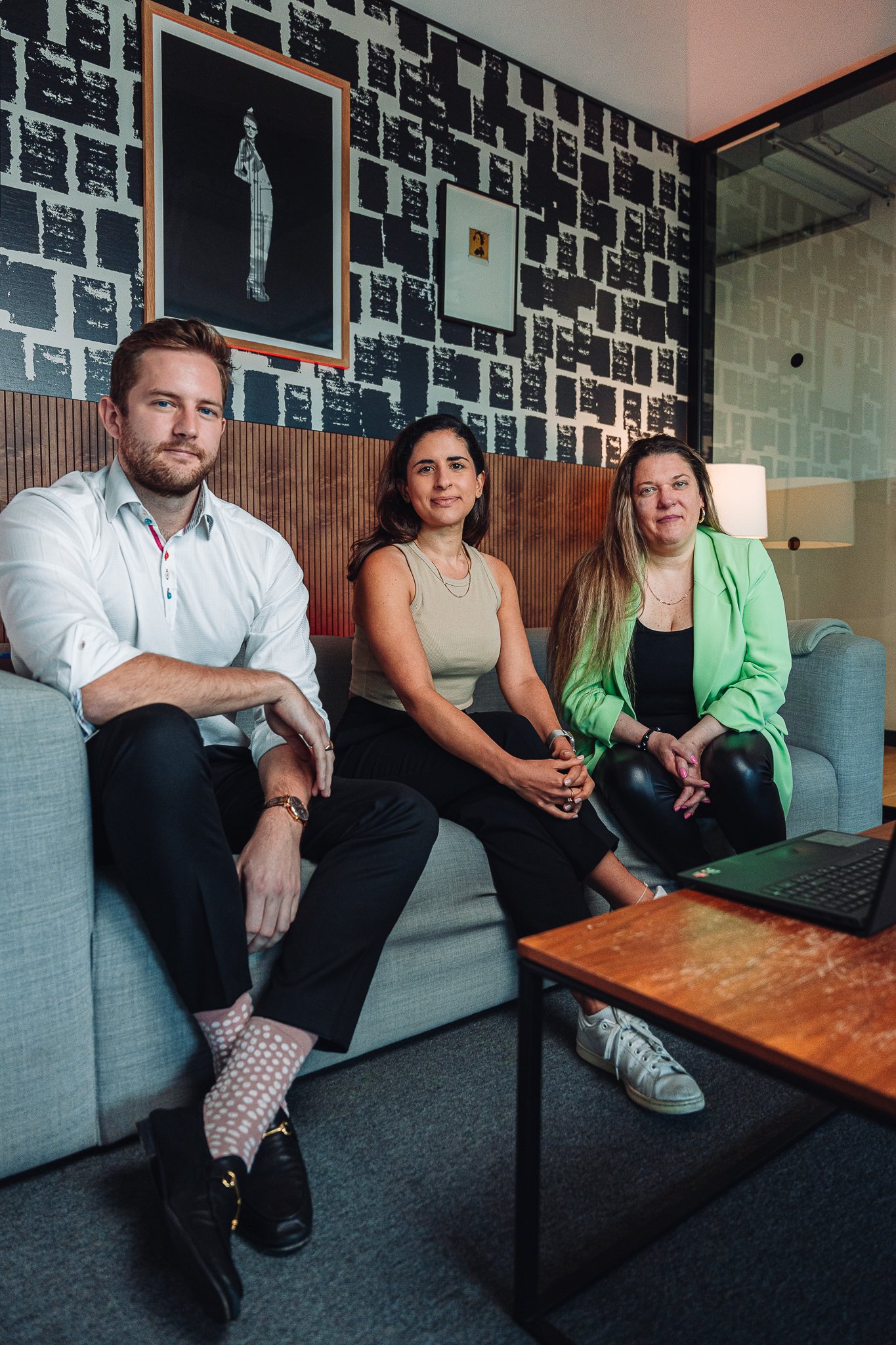 Three people sitting on a bench in front of bushes, representing a Mortgage Adviser firm.