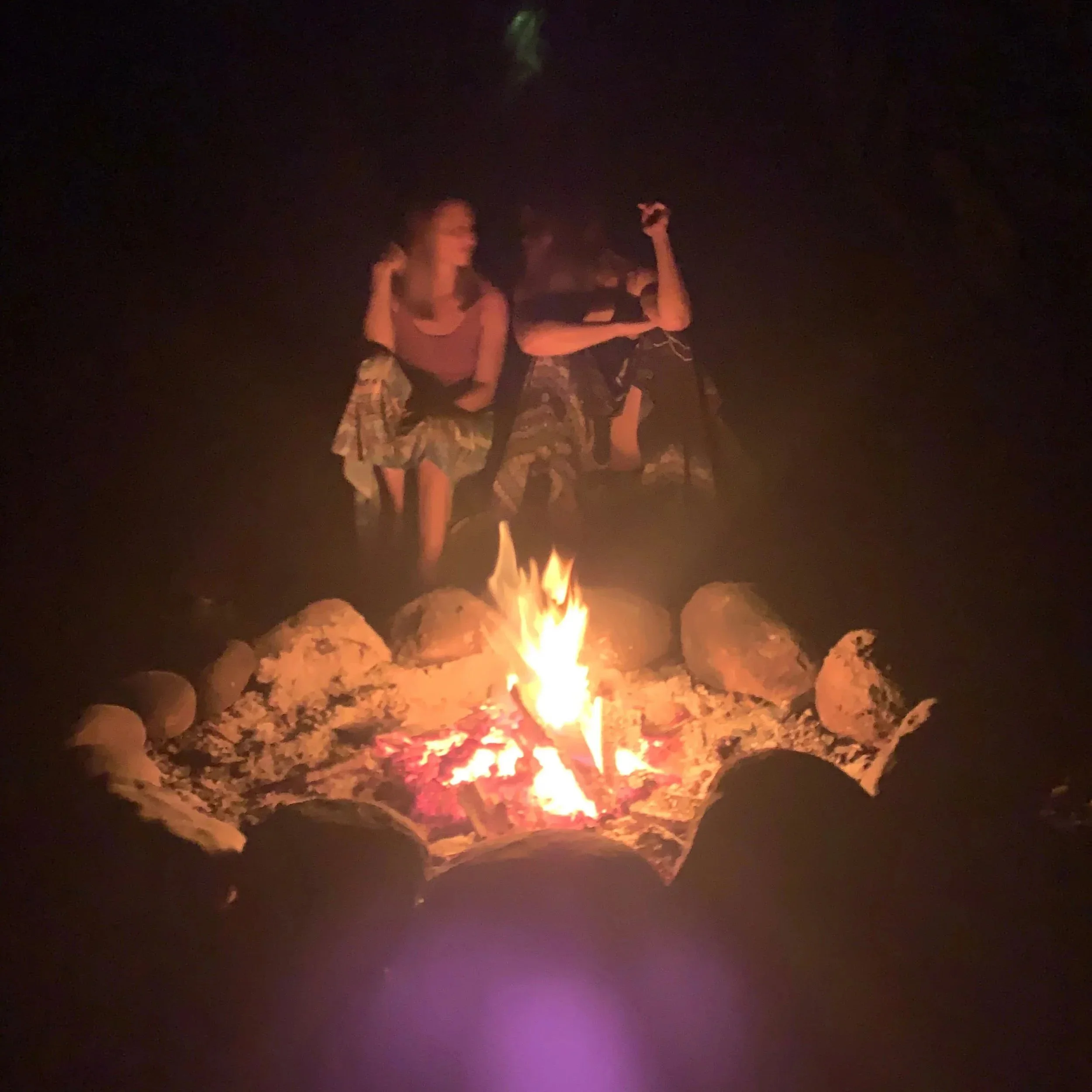 Anke and Marie Lou  sitting around the bonfire after ceremony.