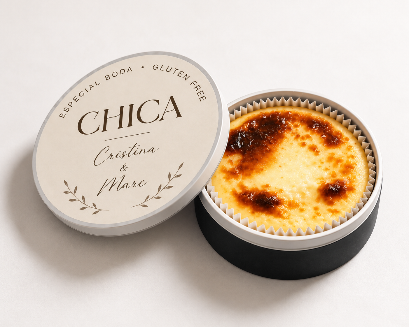 Tarta de crema en caja negra con etiqueta que dice 'Chica Cristina & Marc'