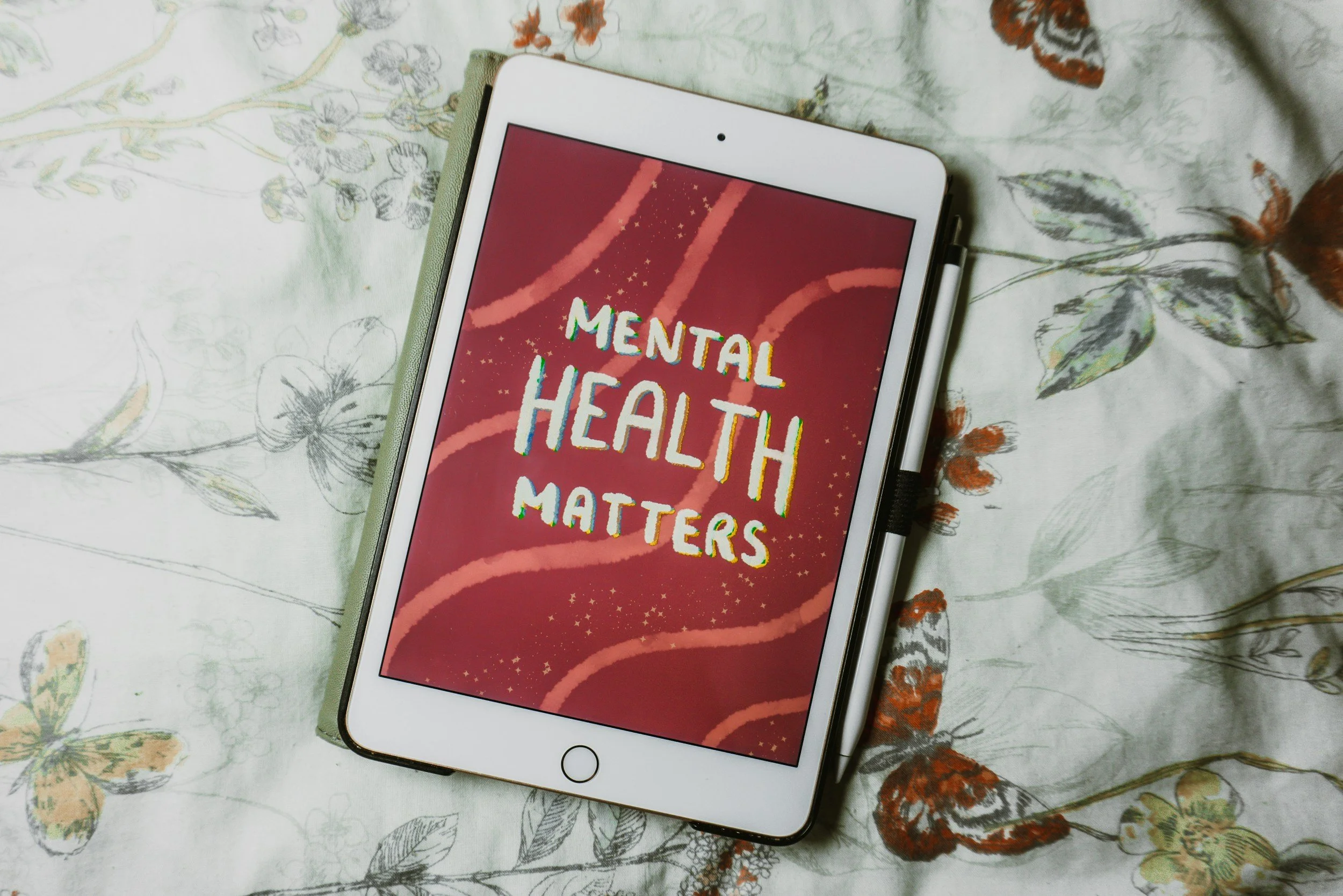 Tablet displaying the words Mental Health Matters on a floral patterned fabric background
