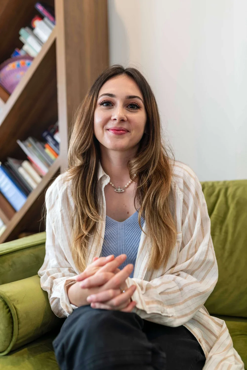 Ruth Ann Alpert, Los Angeles trauma therapist, seated in a therapy office with bookshelves and a green couch