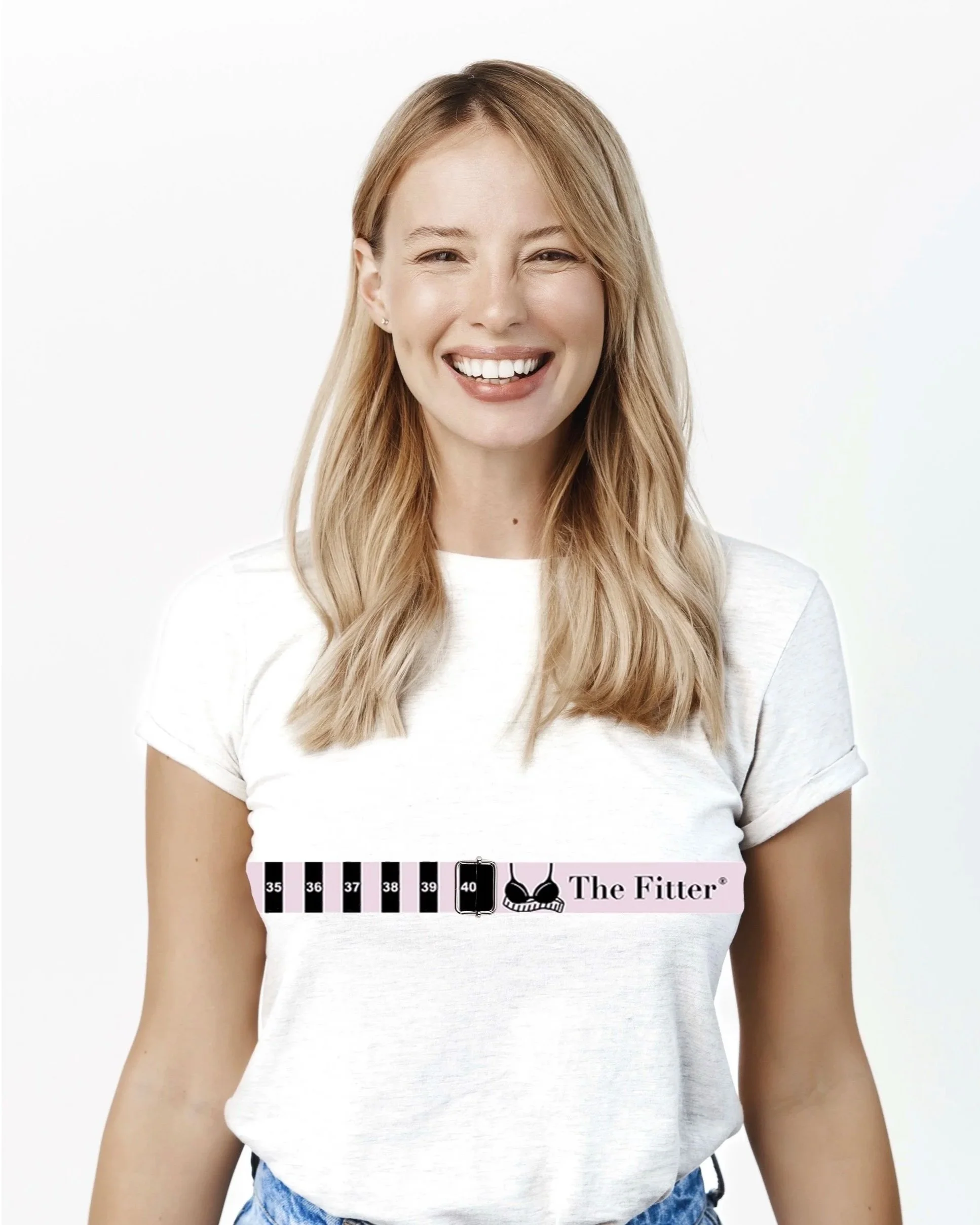 A woman smiling wearing a white T-shirt with a flared rating scale from 35 to 40 and the text "The Fitter" with a bra icon.