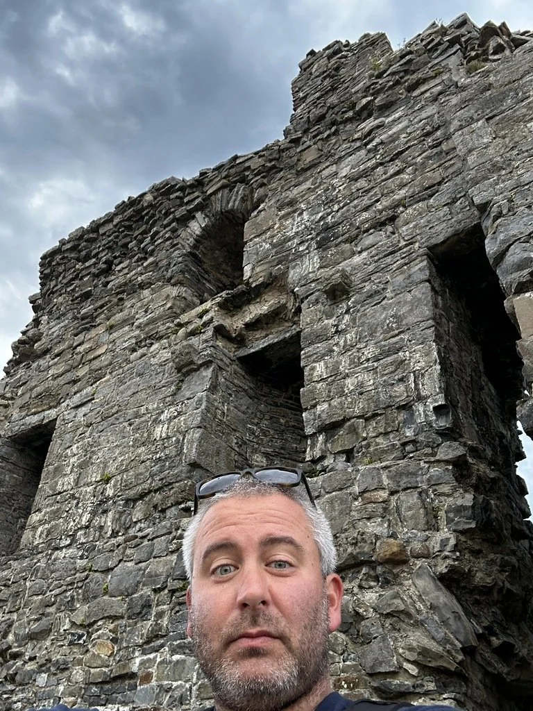 Joe standing beside old stone ruins