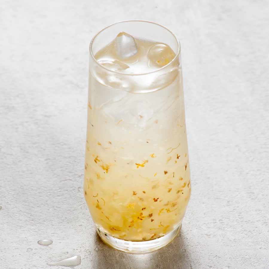 Osmanthus drink with petals and ice – light golden and elegantly floral.