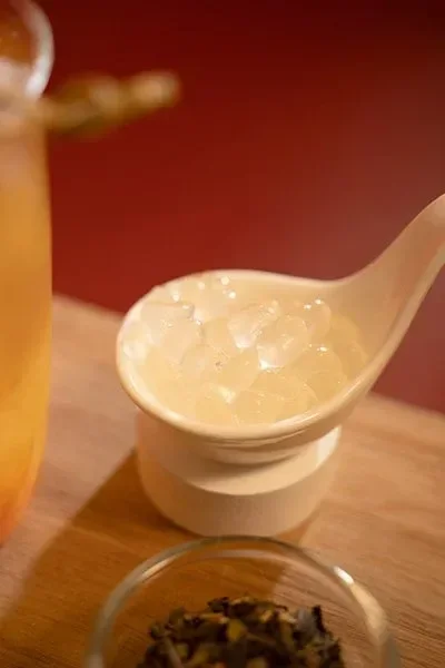 Agar pearls scooped with wooden spoon, low-calorie topping for cold tea and sparkling drinks