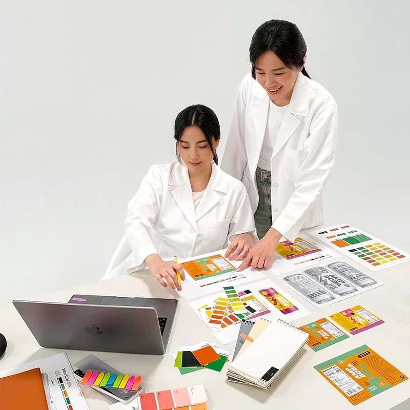 Yujiefood R&D team working on food product packaging design with color samples and label layouts