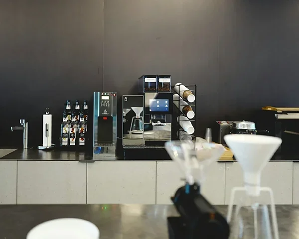 Professional bubble tea bar setup with sealing machine, shaker, and tools on counter