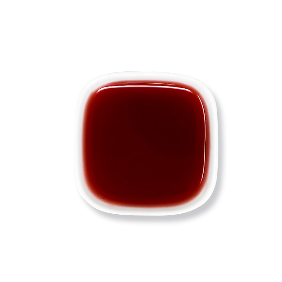 Top view of rose syrup with intense red color and smooth consistency.
