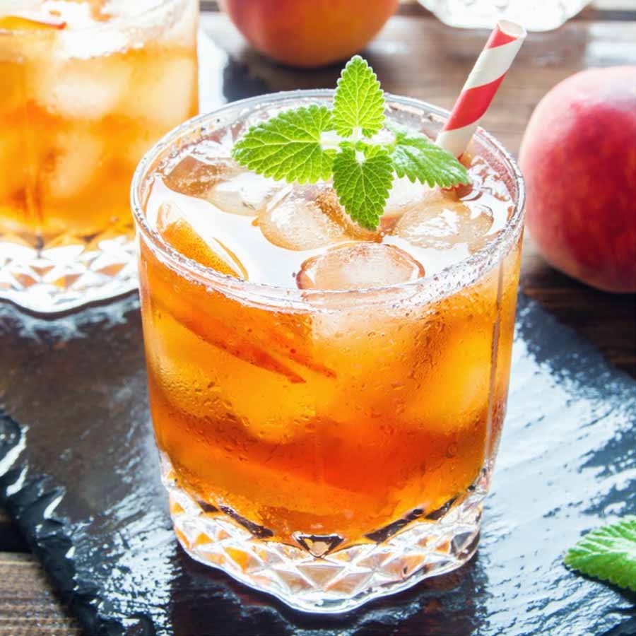 Iced white peach oolong fruit tea with fresh fruits and mint.