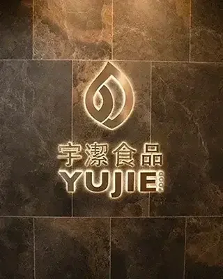 YUJIE FOOD illuminated logo wall at company headquarters, representing a trusted global bubble tea ingredient supplier.