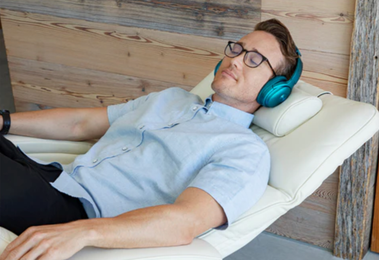 Man laying in chair with headphones