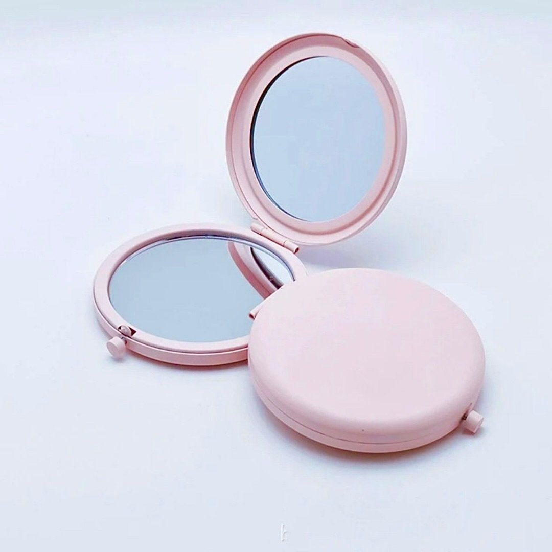 Add a touch of elegance to your daily routine with the “Blush Beauty” compact mirror. This charming accessory features a sleek metal design, finished in a soft, blush pink hue that exudes sophistication. Its compact size makes it perfec