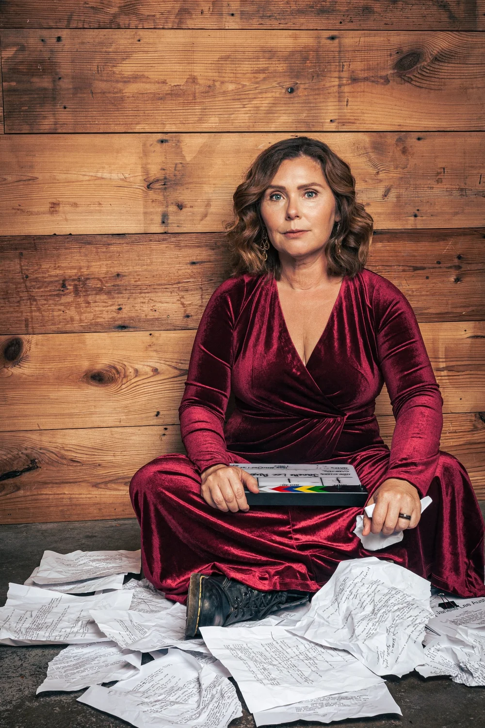 Creative portrait of filmmaker Janelle Lee Austin surrounded by scripts
