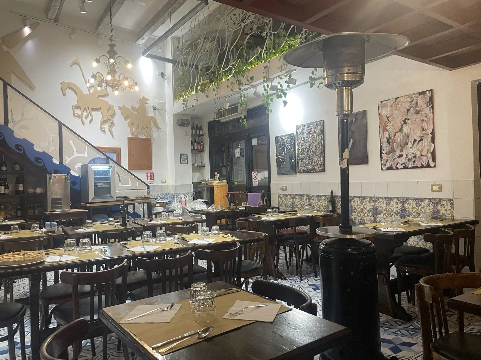 Vegetarian Italian restaurant interior with tables and chairs.