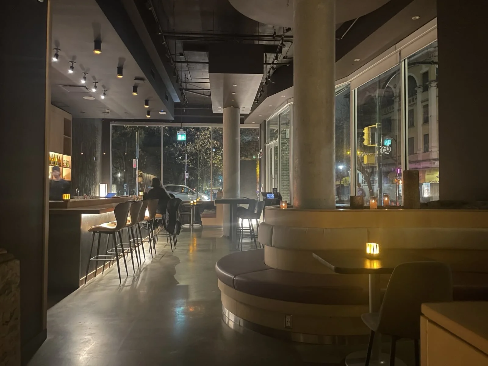 Dark, Japanese restaurant interior with nice lighting and a long bar with stools.