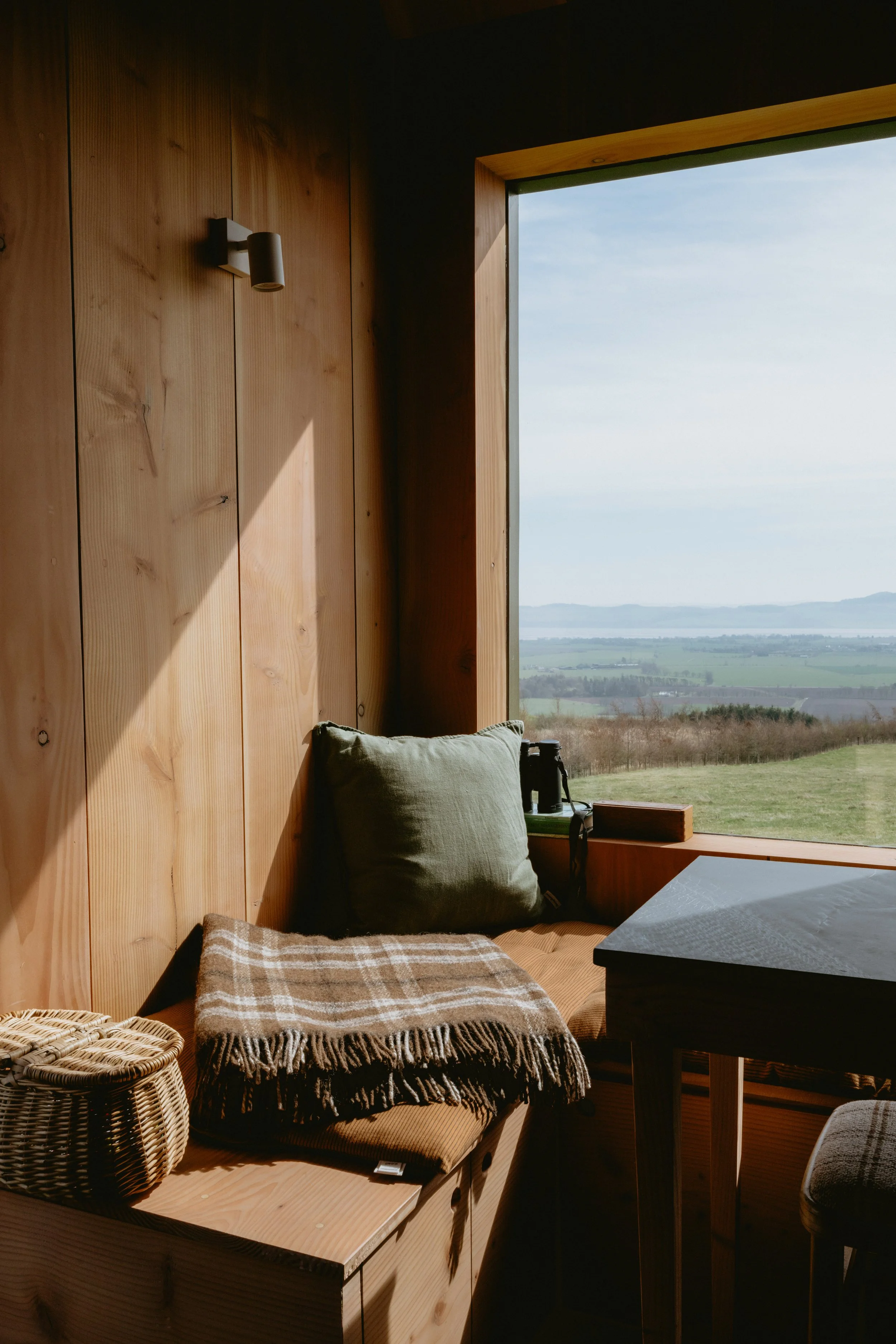 The perfect window seat with cosy homespun blankets, a little wicker basket filled with drawing pencils and watercolour paints. Beautiful douglas fir clad walls. 
