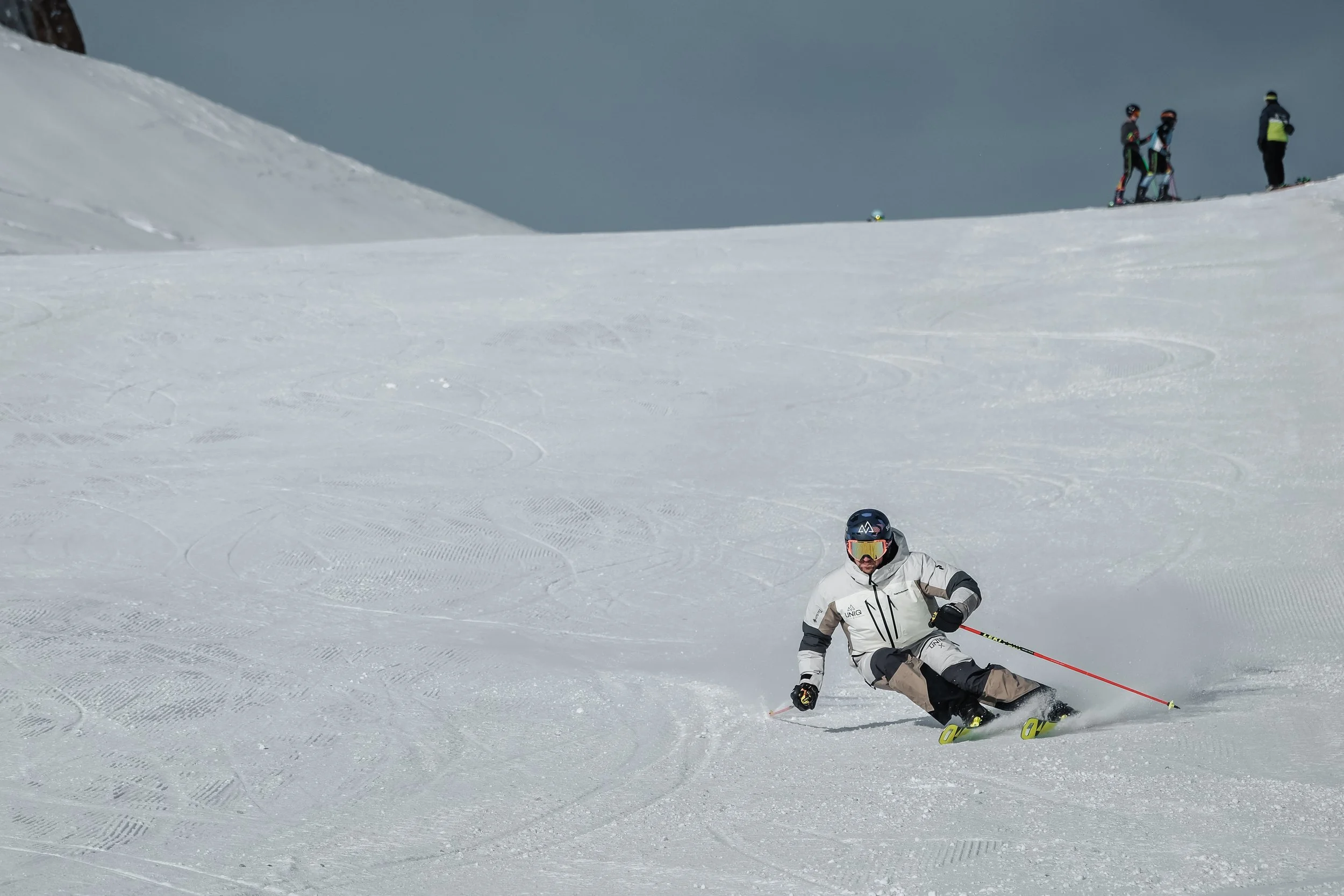 UNIQ skier making a carved turn on firm snow