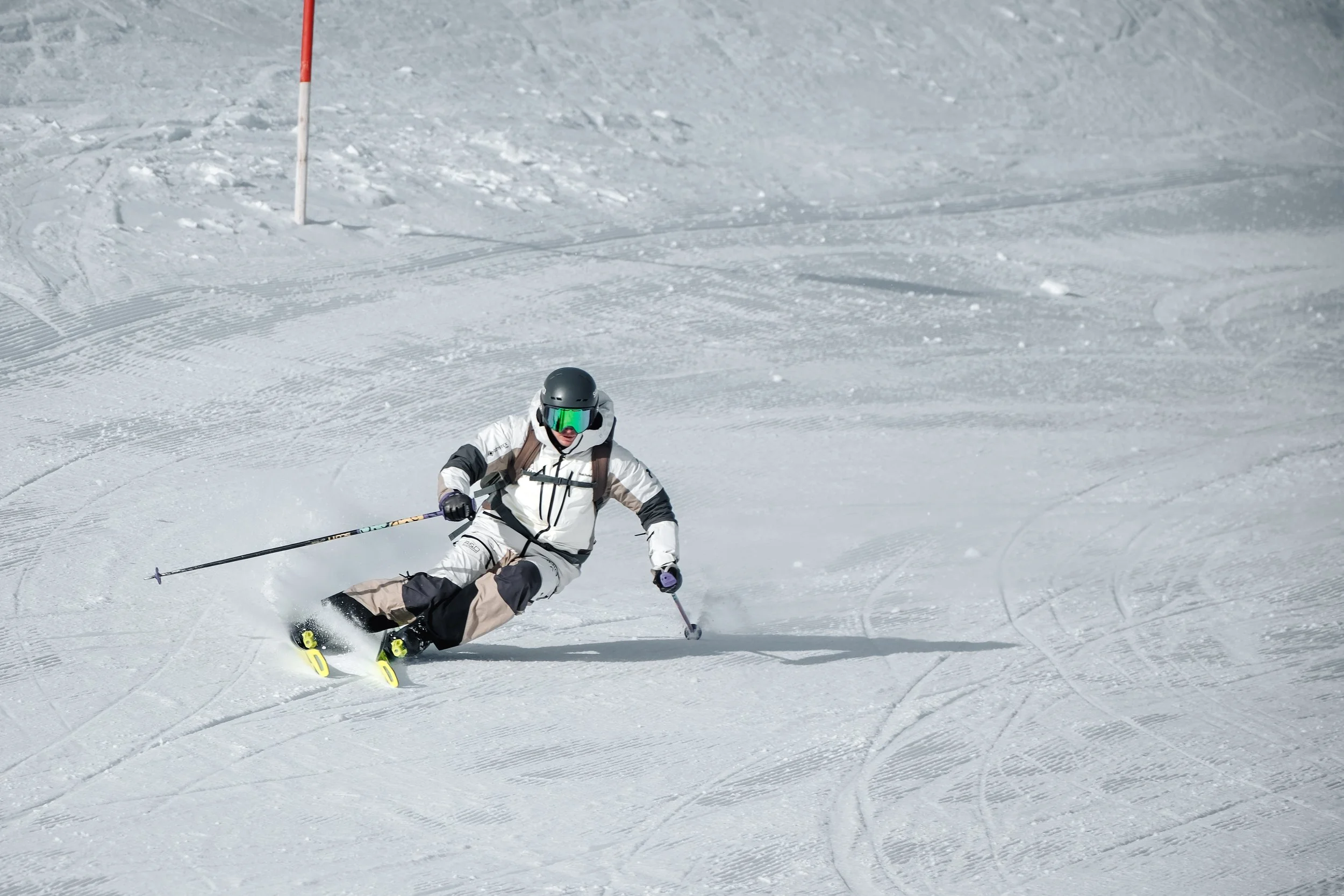 UNIQ skier carving a turn on a groomed slope