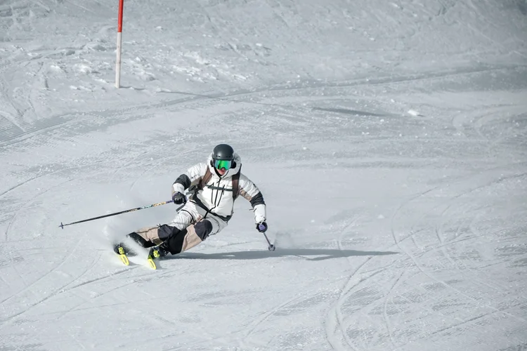 UNIQ skier carving a turn on a groomed slope