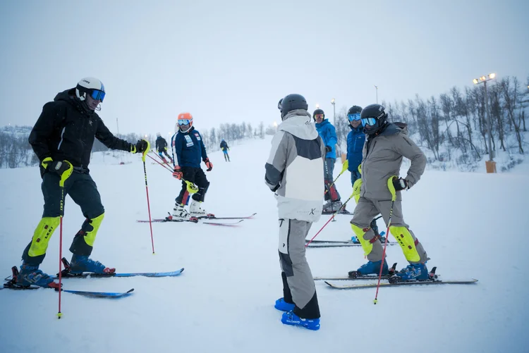 A group of skiers together during an on-snow coaching session